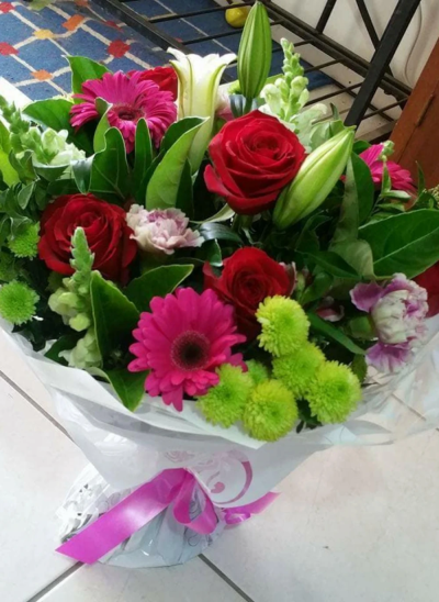 Sweet Romance - Handtied bouqujet of fresh flowers in reds and pinks to include red rosers, gerbera and white lillies